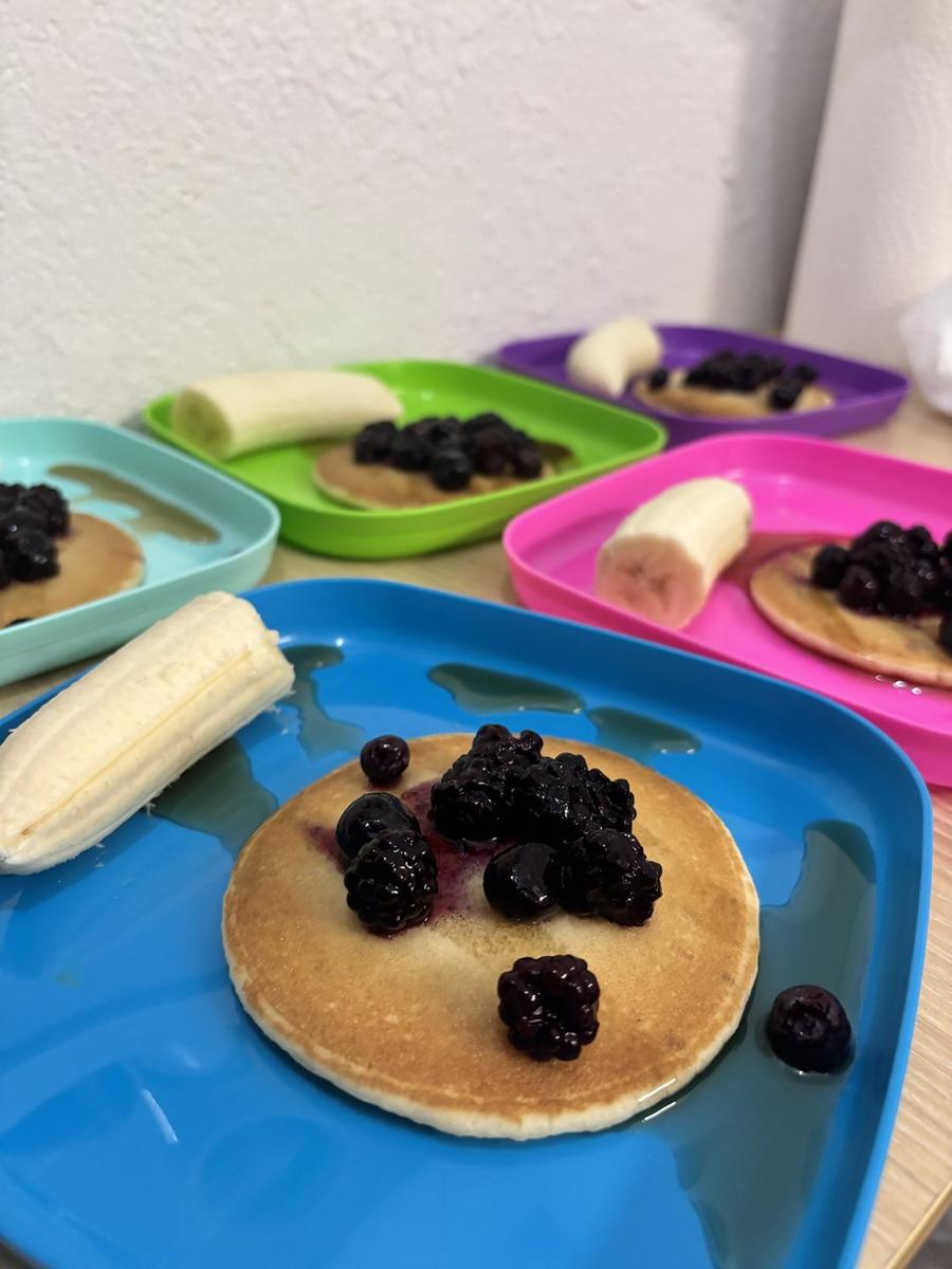 Pancakes topped with blackberries and blueberries with banana